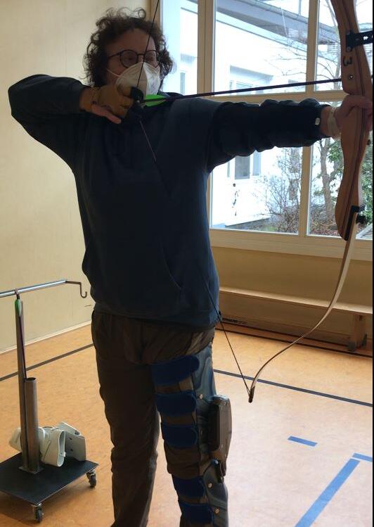 C-Brace-Anwenderin schießt mit Pfeil und Bogen