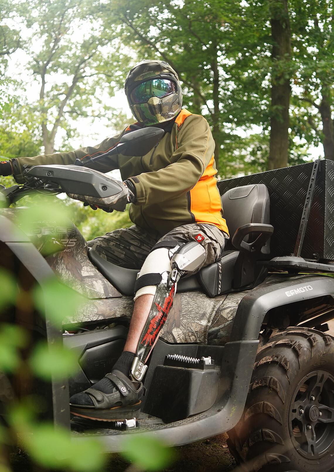 Patient mit einer C-Brace-Versorgung sitzt im Wald auf einem Quad