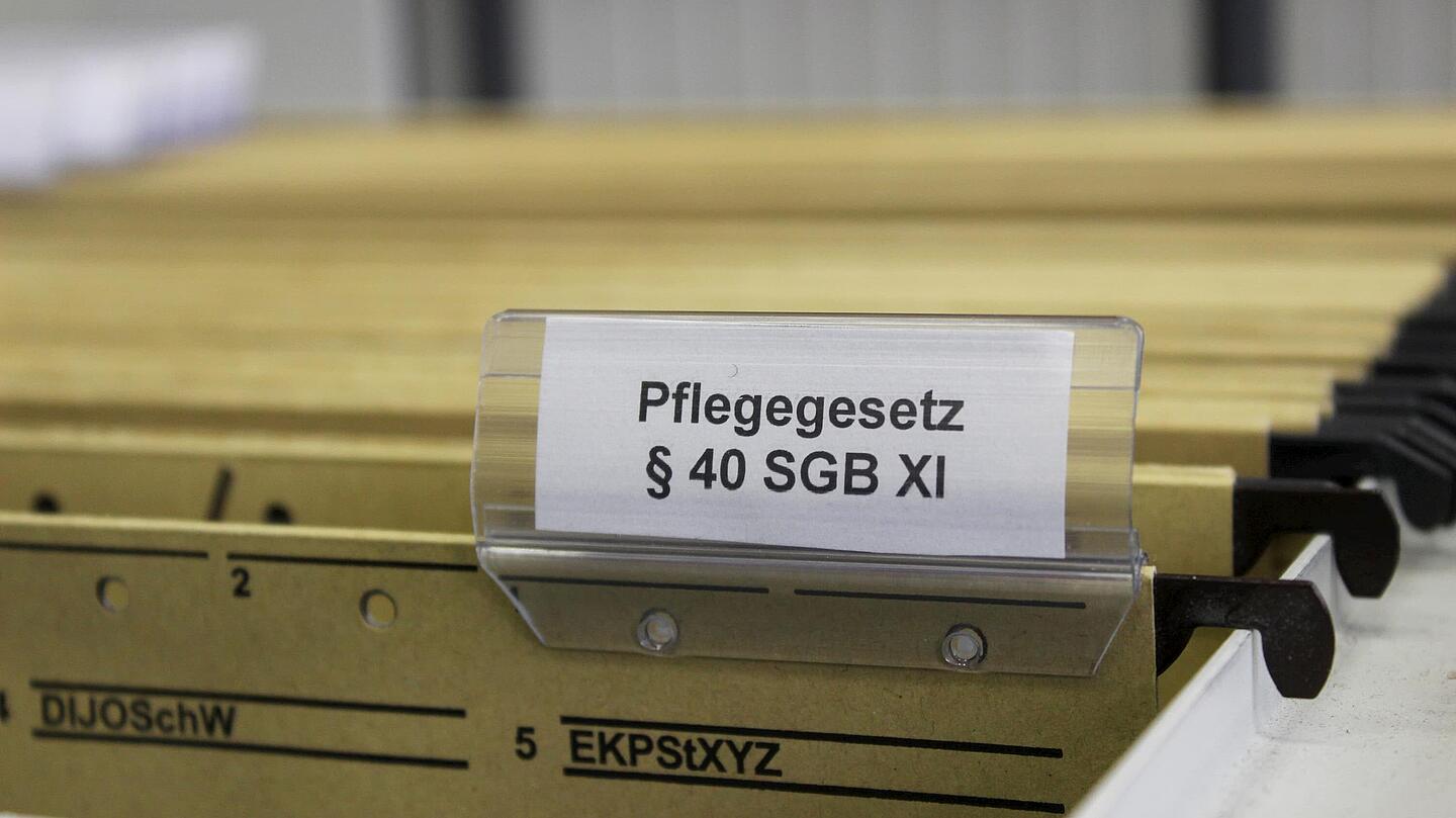 Halterung mit Aktenordnern, bei dem einer mit dem Pflegegesetz beschriftet ist