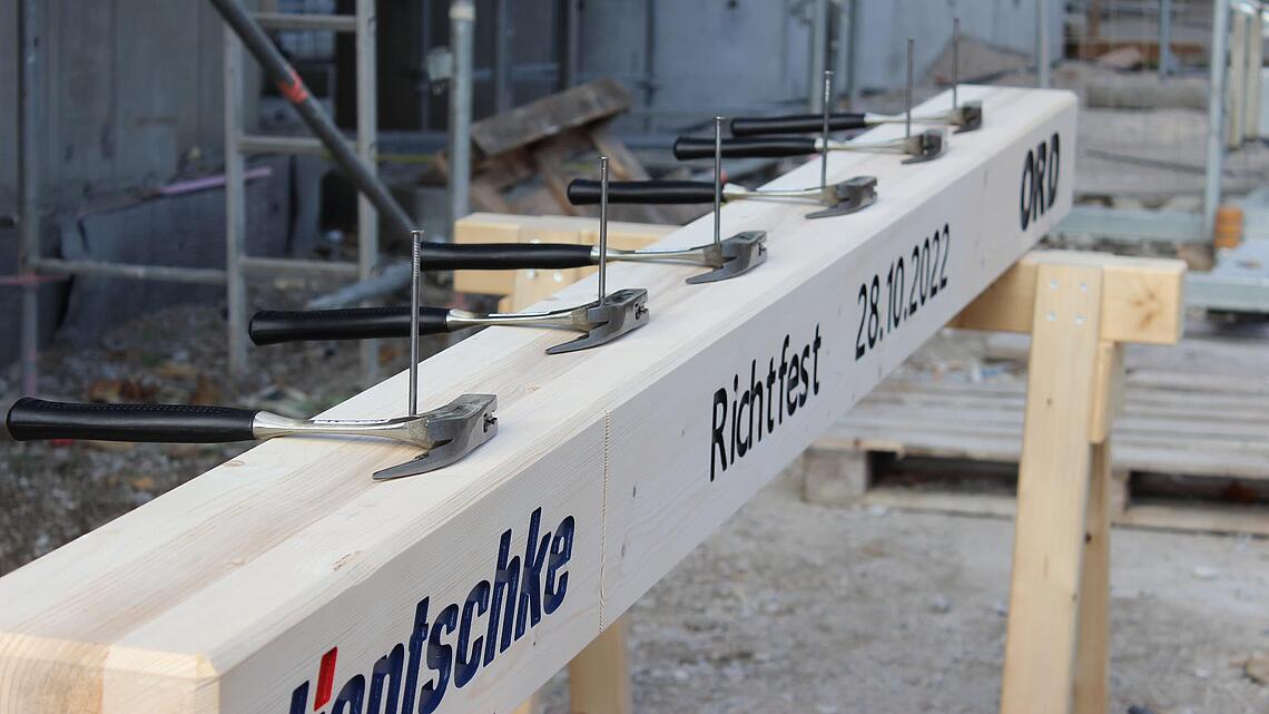 Balken mit Hammer und Nagel im Rahmen des Richtfestes