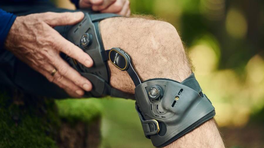 Knie-Orthese Unloader One X von Össur; Mann fässt an die Orthese, © Copyrights by Össur hf