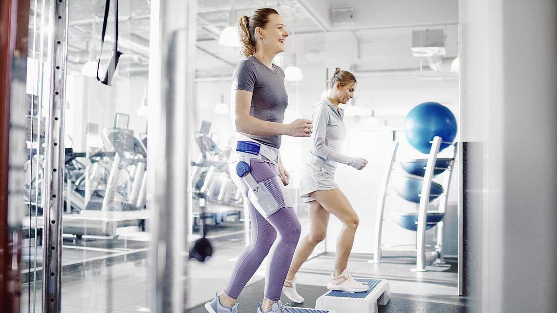 Frau mit Hüft-Orthese Coxa Train beim Sport auf dem Step-Brett, Quelle: Bauerfeind AG, Zeulenroda