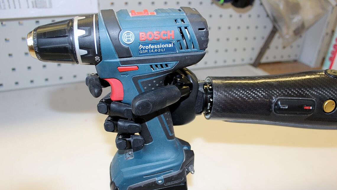 Unterarmprothese mit Hand, die einen Akkuschrauber hält