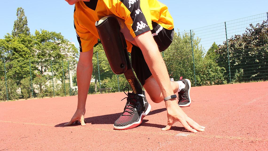 Träger einer Unterschenkel-Sportprothese mit Cheetah-Prothesenfuß in der Startposition zum Sprint