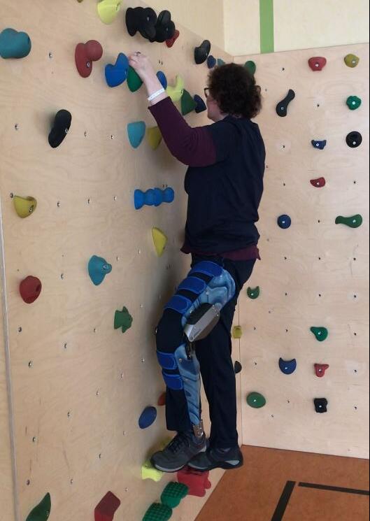 C-Brace-Anwenderin klettert eine Wand hinauf