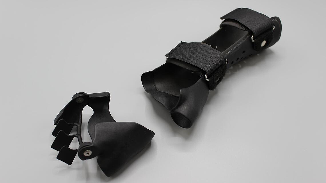 schwarze Ulnardeviationsorthesen aus dem 3D-Drucker, separate Teile für die Fingergrundgelenke und das Unterarm-Handgelenk 