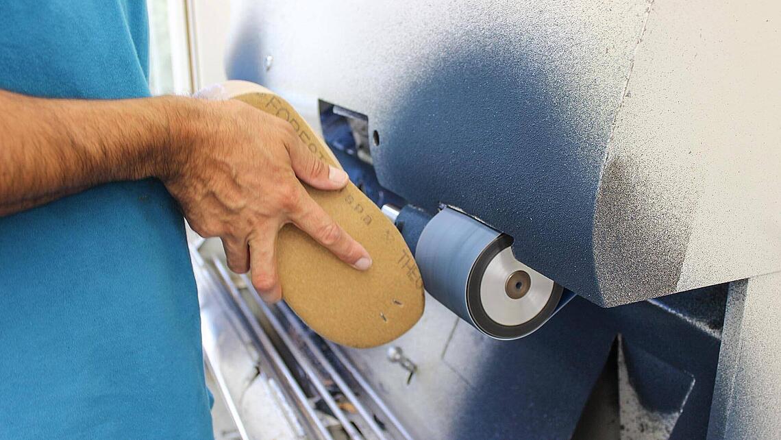 Schuhleiste wird an Bandschleifer zugeschliffen